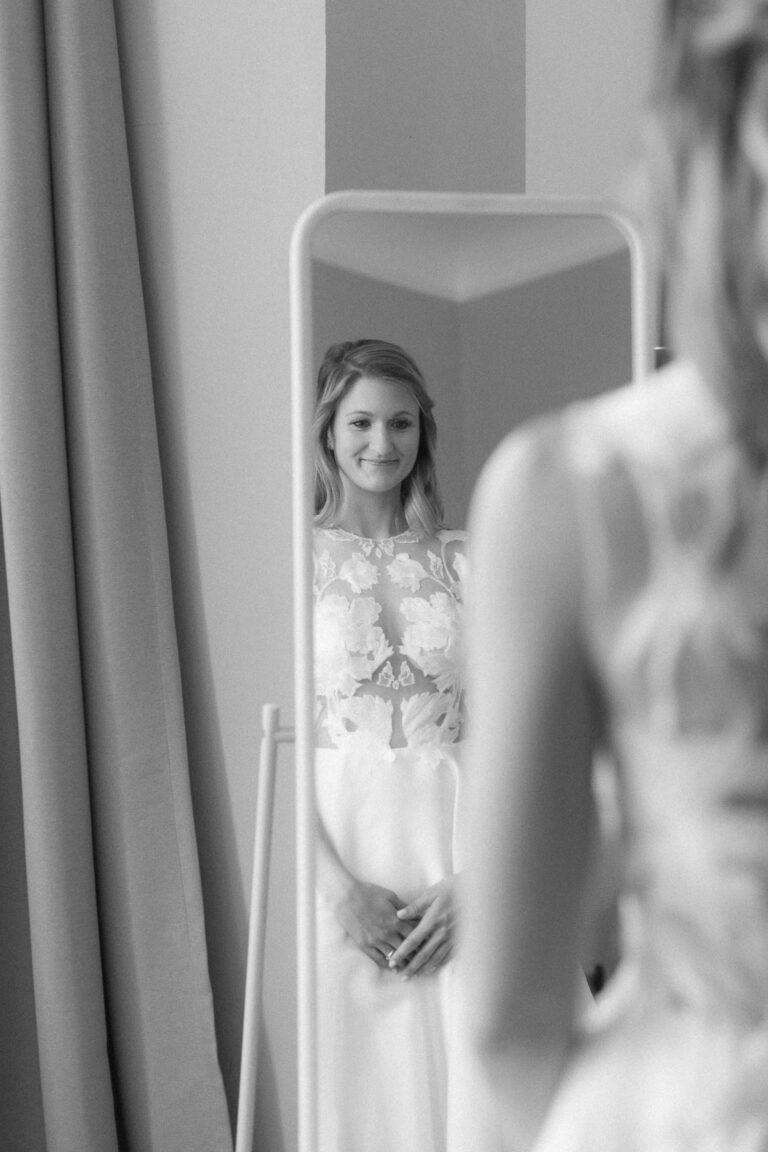 Portrait der Braut während sie sich selbst im Spiegel anschaut
