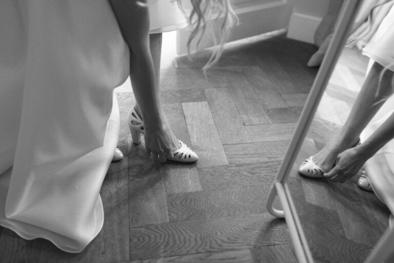 Nahaufnahme der Braut beim Schuhe anziehen auf Gut Sonnenhausen, Hochzeit Gut Sonnenhausen - Alexandra Kasper