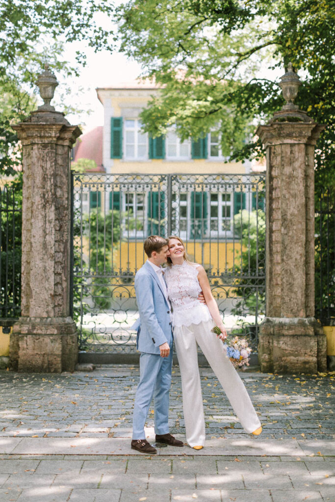 Das Hochzeitspaar im Portrait vor dem Tor des Schloss Suresness, Alexandra Kasper - Hochzeit München