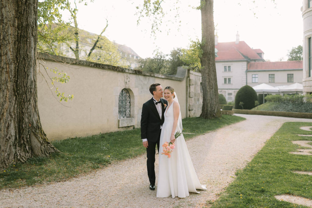Aufnahme von einem Hochzeitspaar welches in die Kamera lacht in München, Alexandra Kasper - Hochzeitsfotograf München
