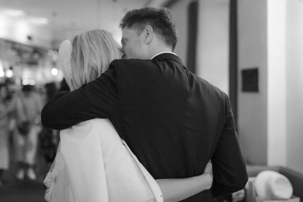 Momentaufnahme während das Hochzeitspaar sich in einem Restaurant in München küsst, Alexandra Kasper - Hochzeit Restaurant München