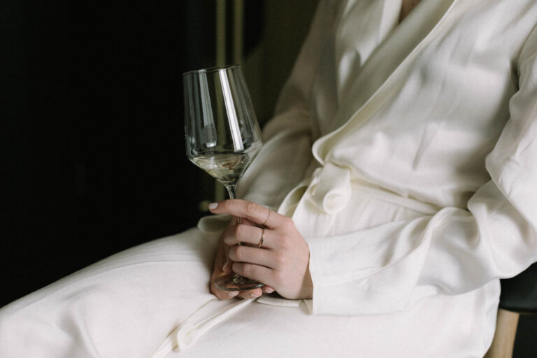 Detailaufnahme von der Hand der Braut mit einem Glas Wein