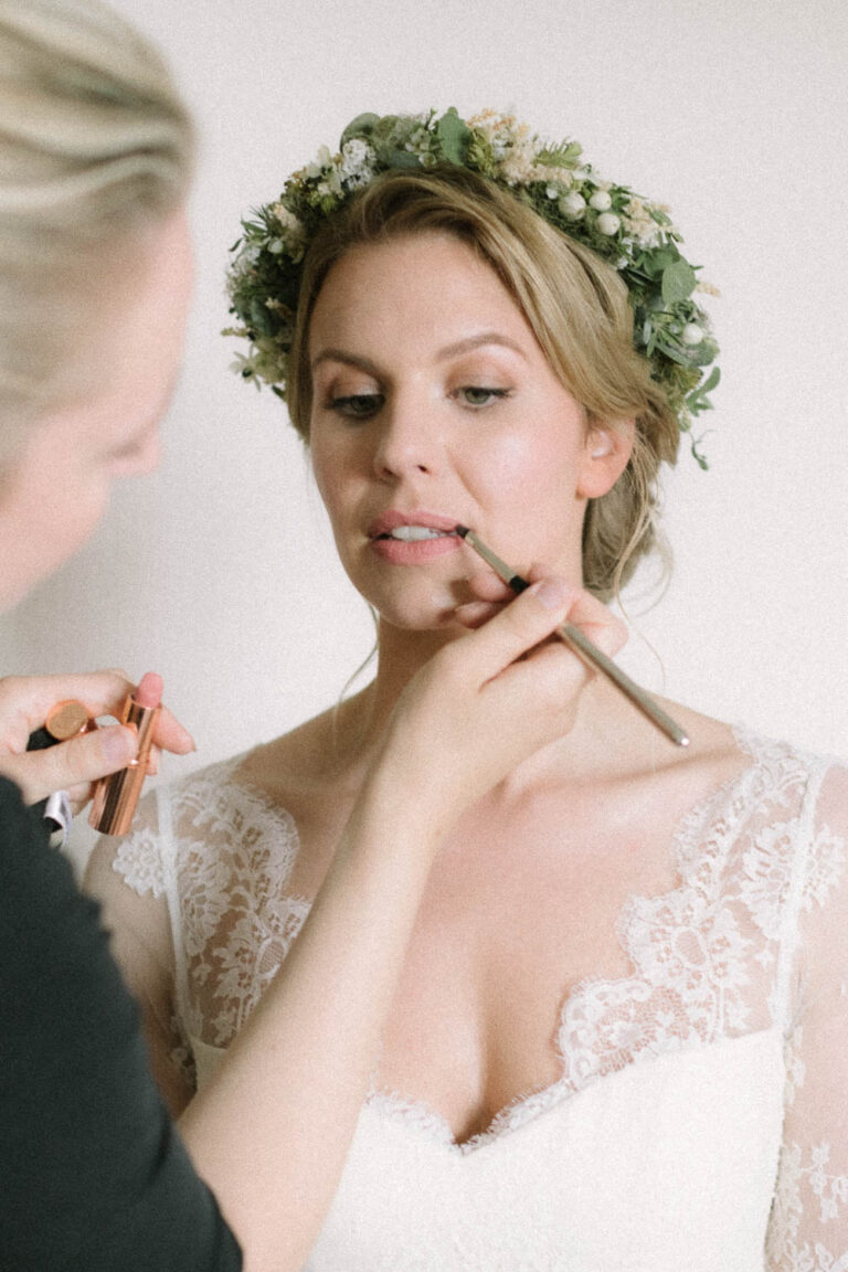 Portrait der Braut beim auftragen vom Lippenstift