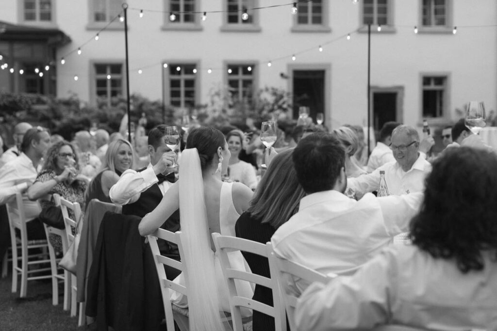 Die Stimmung am Abend als alle Gäste am Tisch Wein trinken, Alexandra Kasper - Hochzeitsfotograf München
